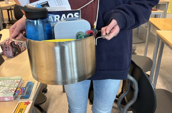 en person som holder en metallbøtte