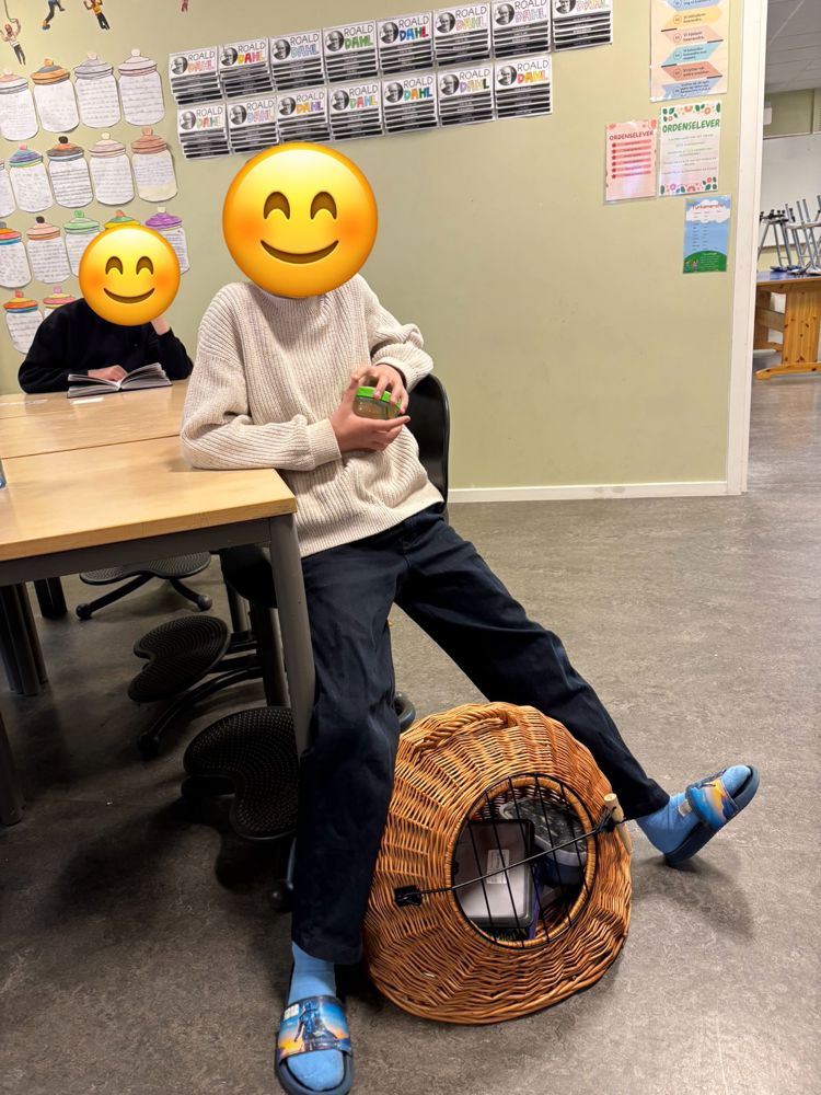 en person som sitter på en stol med en kurv og en kurv med et ansikt tegnet på den