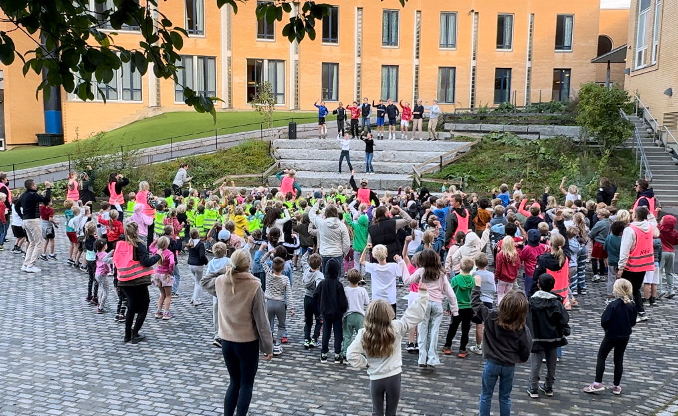 en gruppe mennesker som står på en gårdsplass foran en bygning