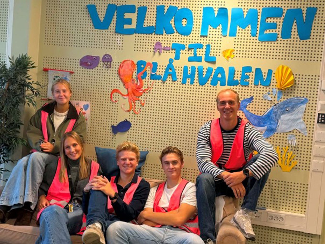 en gruppe mennesker som sitter i en sofa og poserer for kameraet en gruppe mennesker som sitter i en sofa og poserer for kameraet