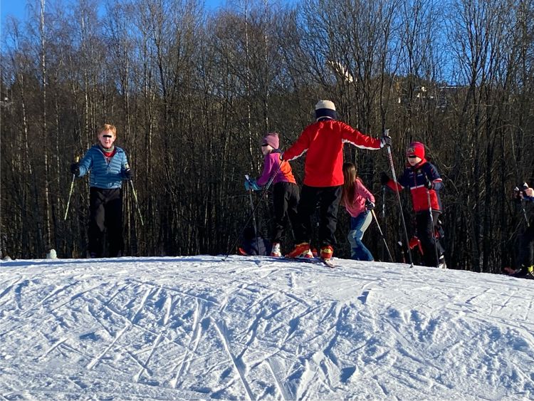 En gruppe mennesker står på snøski