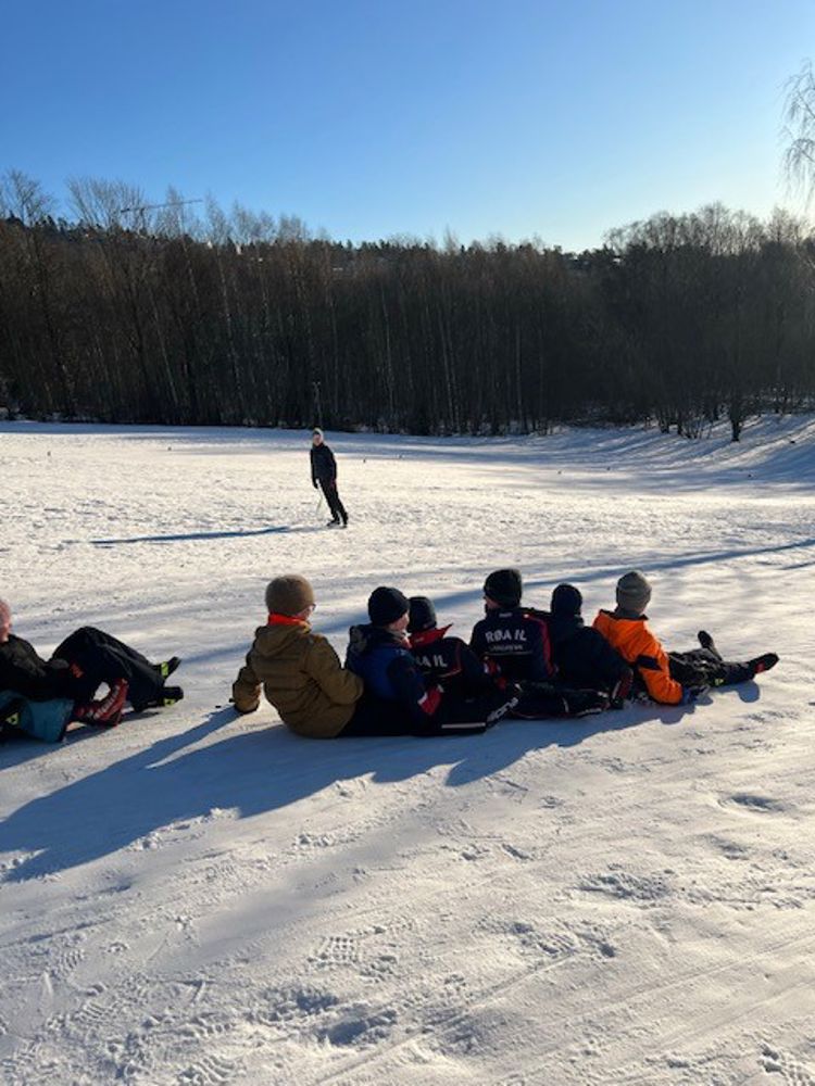 en gruppe mennesker som sitter på snøen