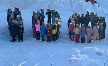 en gruppe mennesker som står i snøen