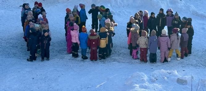 en gruppe mennesker som står i snøen