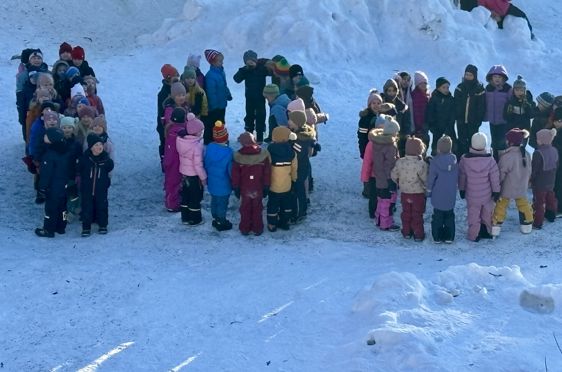 en gruppe mennesker som står i snøen