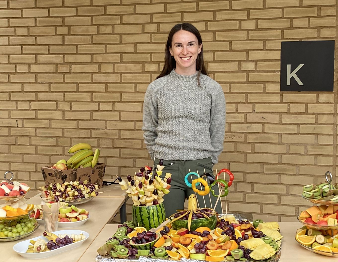 en person som står ved siden av et bord med mat