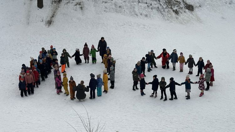 en gruppe mennesker som står i snøen