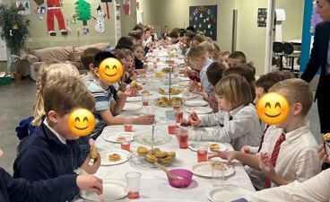 en gruppe barn som spiser ved et bord