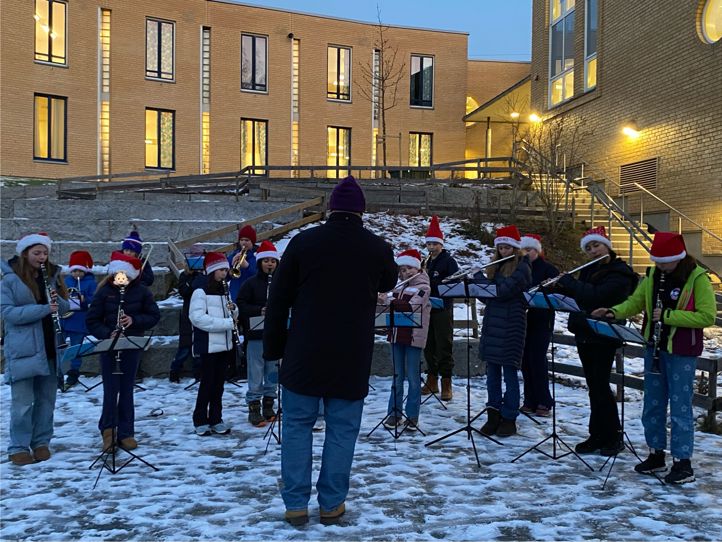 en gruppe mennesker som står i snøen med en person som står foran dem