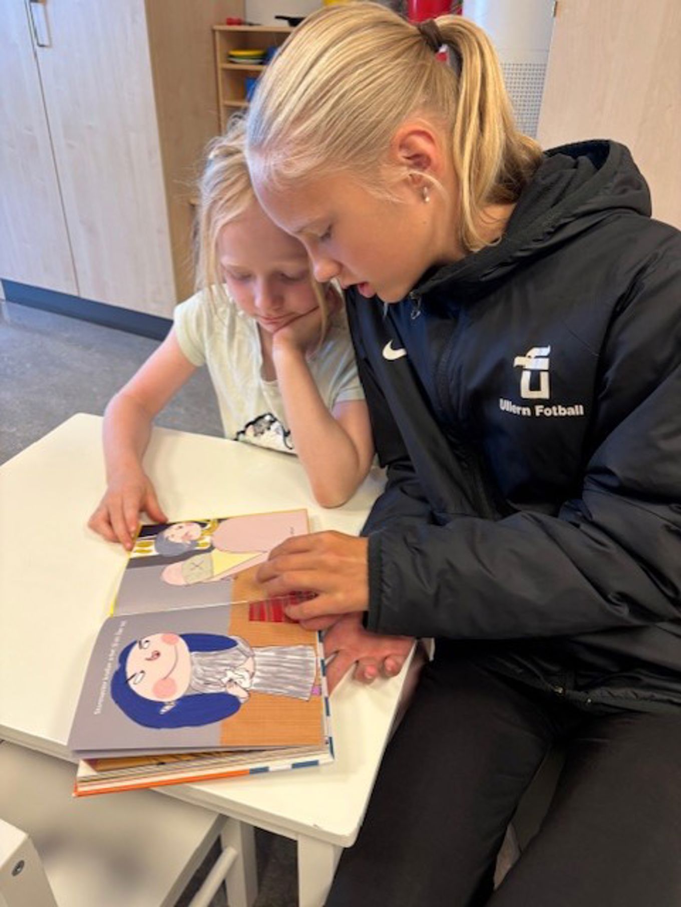 en person og et barn som ser på en bok