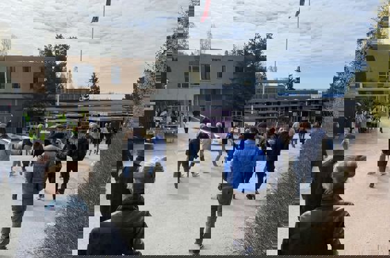 en gruppe mennesker som går rundt en bygning