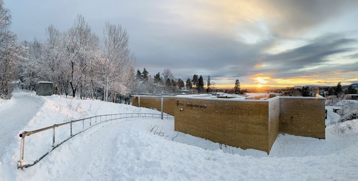 et snødekt landskap med mur og trær