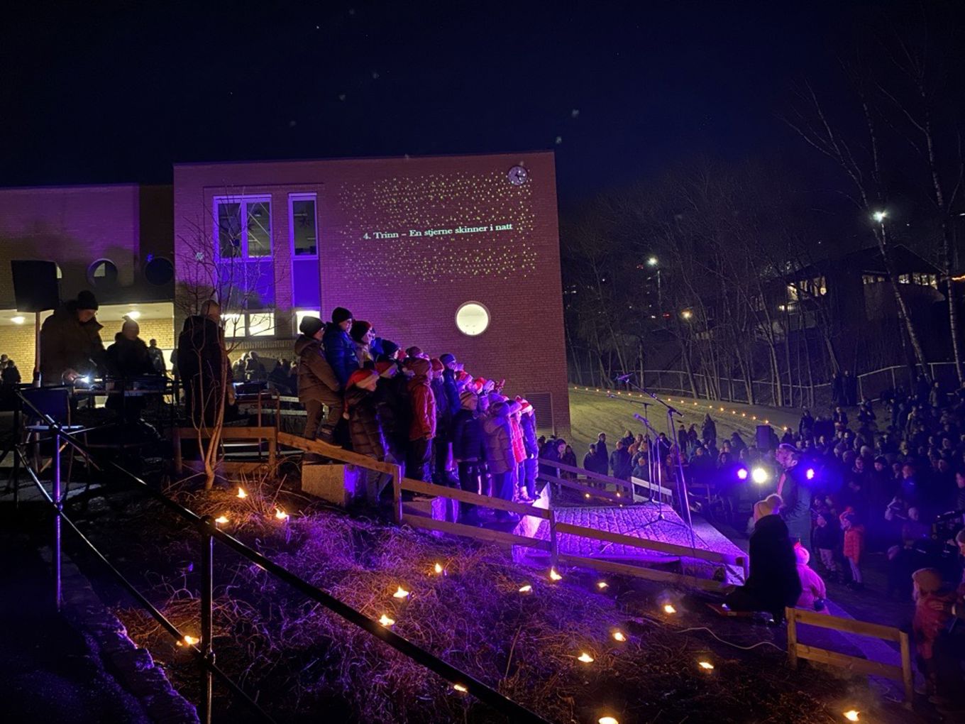 en gruppe mennesker som står rundt en scene med lys