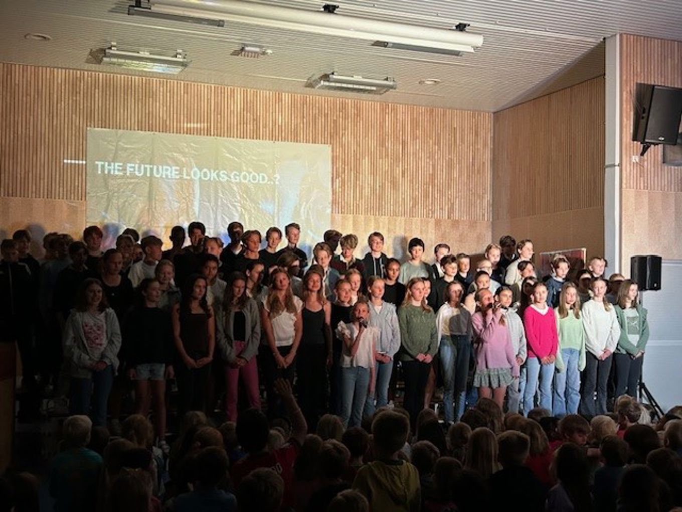 en gruppe mennesker som står i et rom en gruppe mennesker som står i et rom