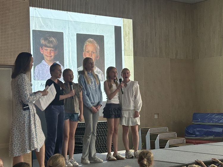 en gruppe mennesker som står foran en scene en gruppe mennesker som står foran en scene