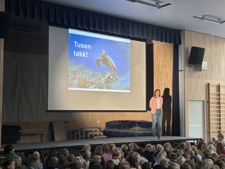 en person som står på en scene foran en folkemengde